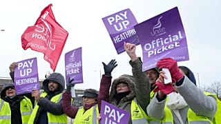 Members of the Unite union stand at a picket line near Heathrow Airport in London.