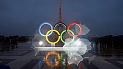 The iconic Olympic rings in front of the equally iconic Eiffel Tower in Paris