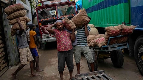 Laborers load sacks of imported potatoes to hand carts at a market place in Colombo, Sri Lanka, Tuesday, March 21, 2023. 