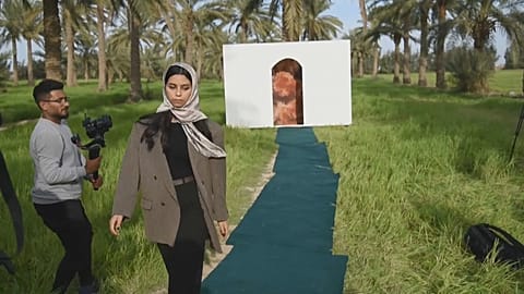 A model promotes green fashion at a palm-grove catwalk show in Iraq. March 21, 2023