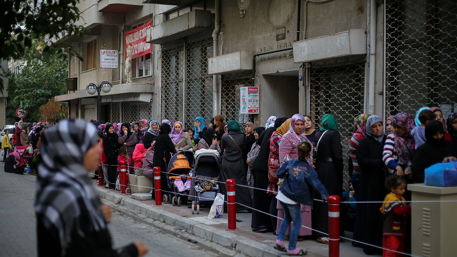 Syrische Familien warten in einer Schlange auf Hilfsgüter, die von UNICEF in Izmir verteilt werden