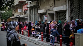 Syrian families wait in line for aids distributed by the UNICEF in Izmir, 2015