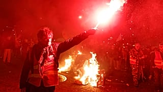 Protesters take part in a torchlight demonstration against the raising of the retirement age in Nantes, western France, Tuesday, March 21, 2023