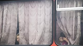 کودکان پیش از این که به ایستگاه برای انتقال به کمپ پناهندگان روسیه در حدود ۱۰ کیلومتری مرز اوکراین بروند از پنجره اتوبوس به بیرون نگاه می‌کنند. 