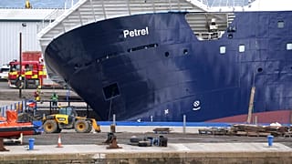 Emergency services work at Imperial Dock, where a ship has become dislodged from its holding and is partially toppled over, in Leith, Edinburgh, Scotland.
