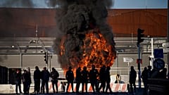 Dock workers stand in front of a burning barricade next the port of Marseille southern France, Wednesday, March 22, 2023.