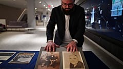 Christopher Lynch, music historian at the University of Pittsburgh, adjusts photos of Gospel music composer, Charles Henry Pace