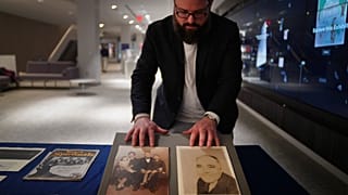 Christopher Lynch, music historian at the University of Pittsburgh, adjusts photos of Gospel music composer, Charles Henry Pace