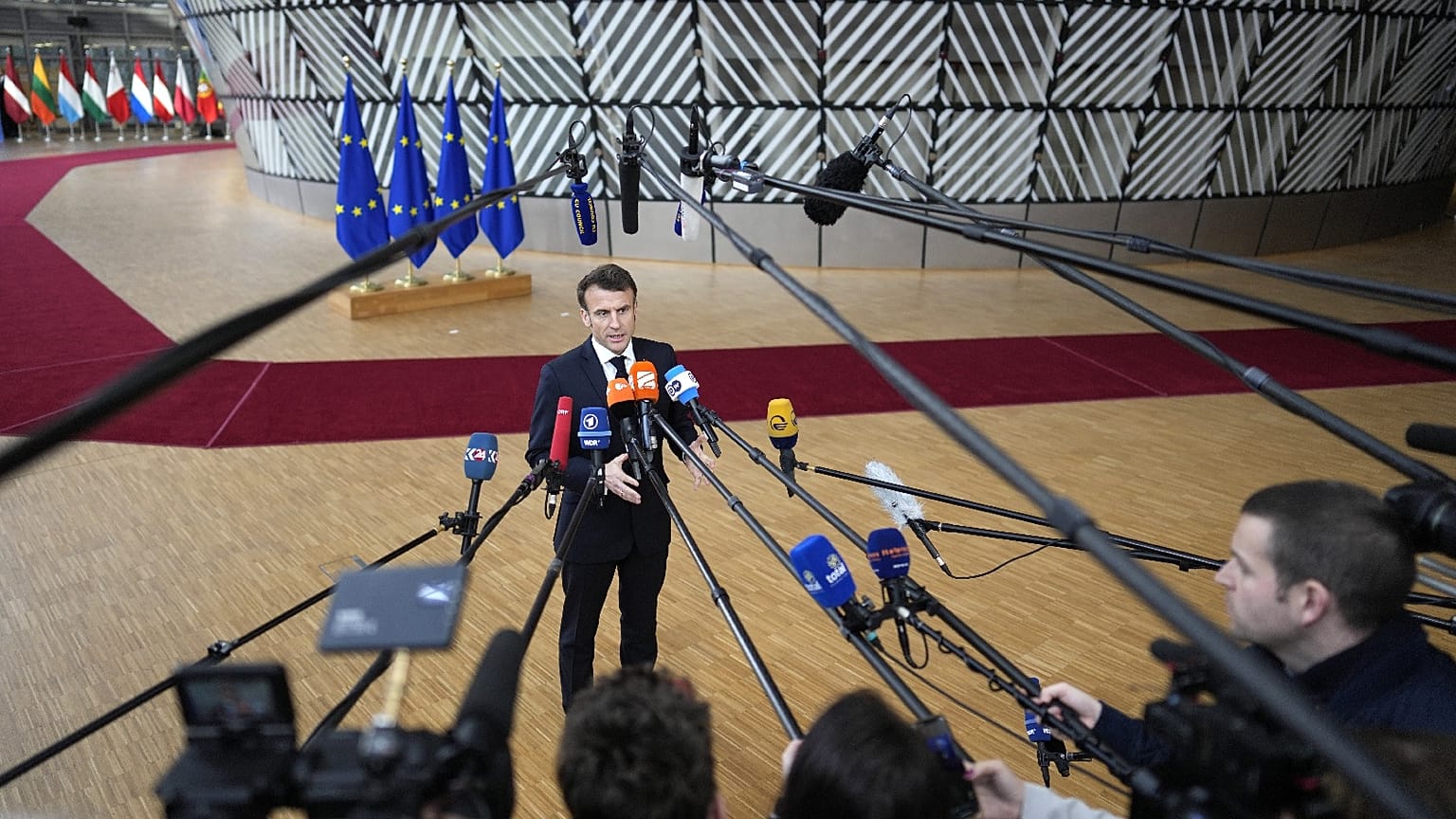 France's President Emmanuel Macron speaks with the media as he arrives for an EU summit at the European Council building in Brussels on Feb. 9, 2023.