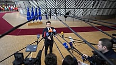 France's President Emmanuel Macron speaks with the media as he arrives for an EU summit at the European Council building in Brussels on Feb. 9, 2023.