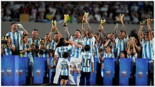 ميسي وهو يرفع نسخة من كأس العالم رفقة زملائه في المنتخب الأرجنتيني