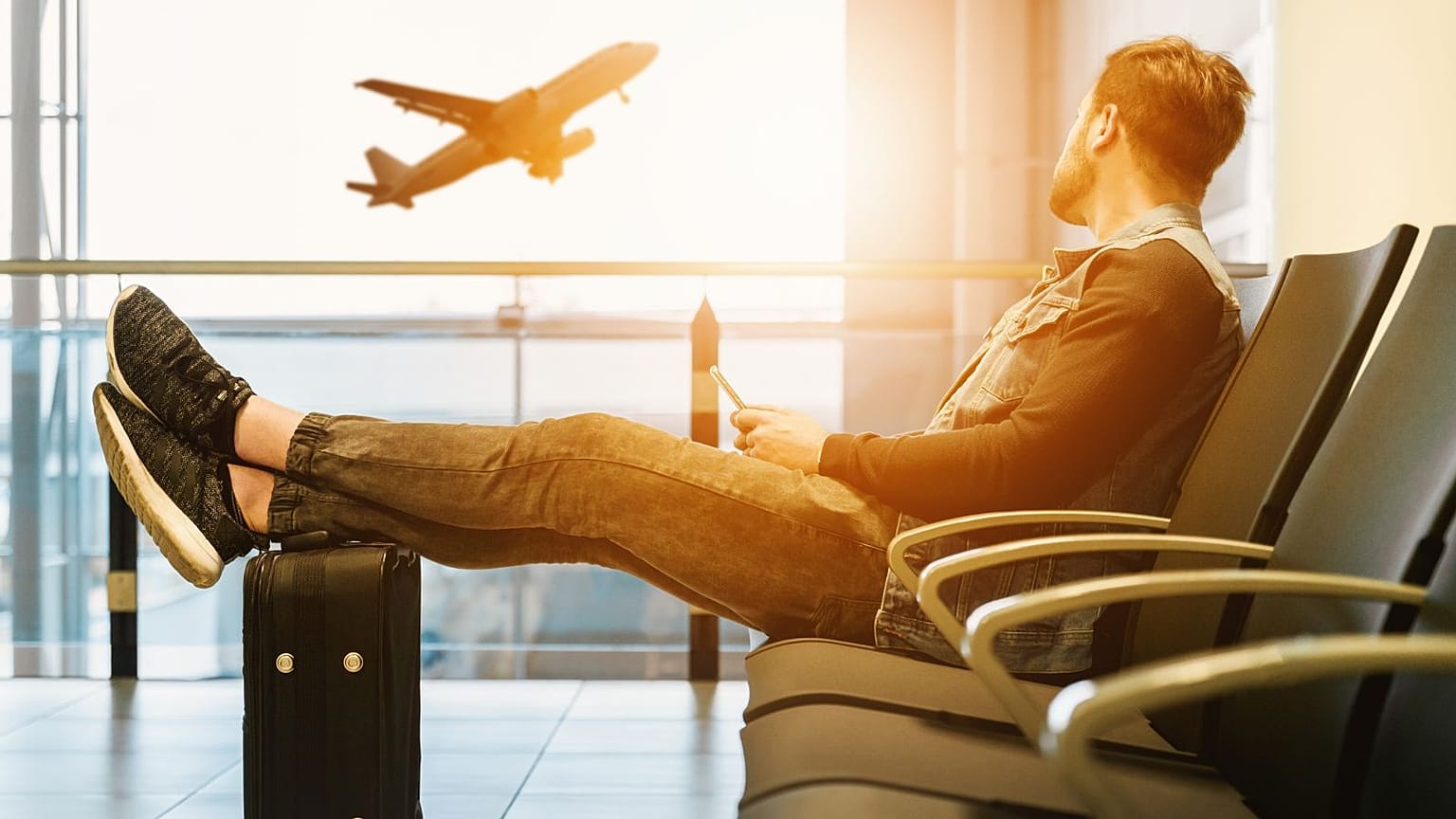 A man awaits his flight at an airport.
