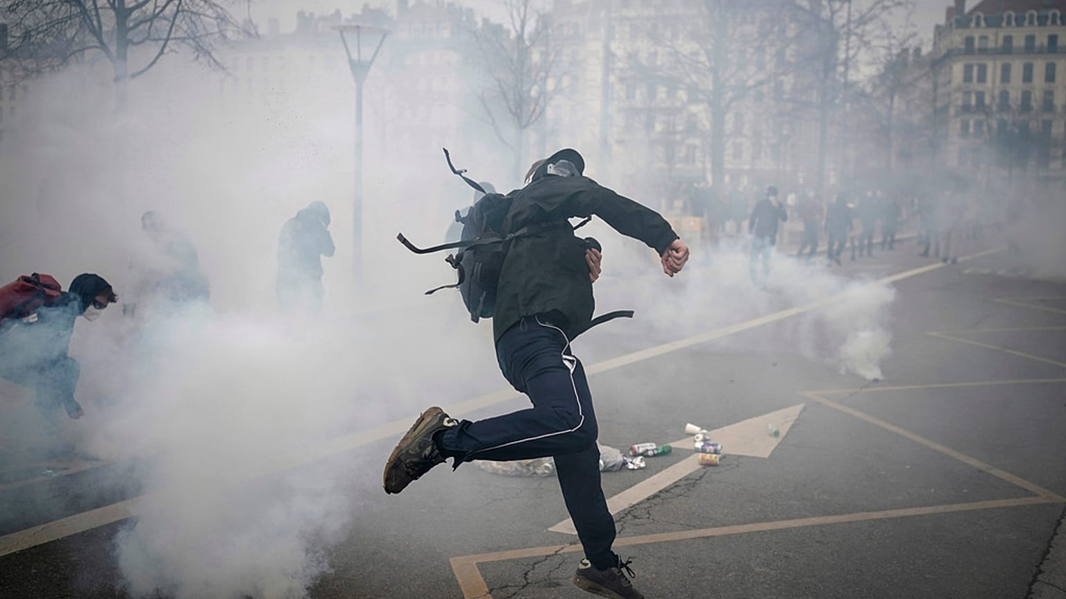 Une personne jette des pierres contre les forces de l'ordre en marge d'une manifestation contre la réforme des retraites, le 23 mars 2023 à Lyon, France