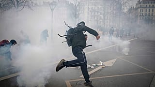 Une personne jette des pierres contre les forces de l'ordre en marge d'une manifestation contre la réforme des retraites, le 23 mars 2023 à Lyon, France