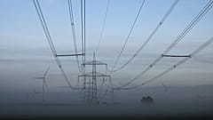 Turbinas eólicas ao lado de postes de eletricidade perto de Muencheberg, na Alemanha
