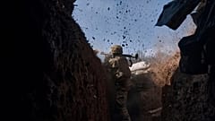 A Ukrainian soldier of the 28th brigade fires from a grenade launcher on the frontline during a battle with Russian troops near Bakhmut, 24 March 2023
