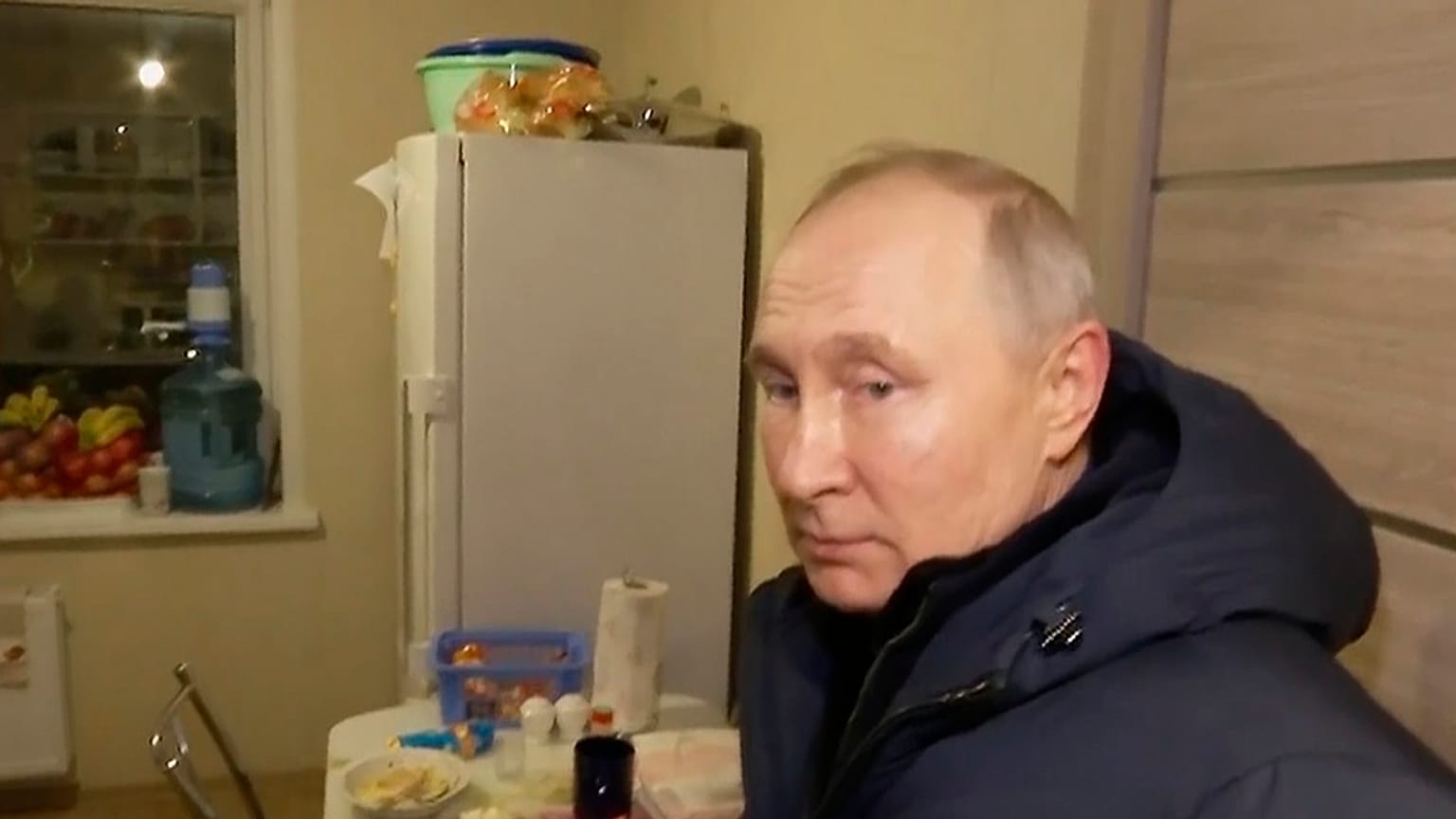Le président russe Vladimir Poutine écoute les habitants de leur nouvel appartement lors de sa visite à Marioupol le dimanche 19 mars 2023