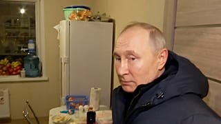 Le président russe Vladimir Poutine écoute les habitants de leur nouvel appartement lors de sa visite à Marioupol le dimanche 19 mars 2023