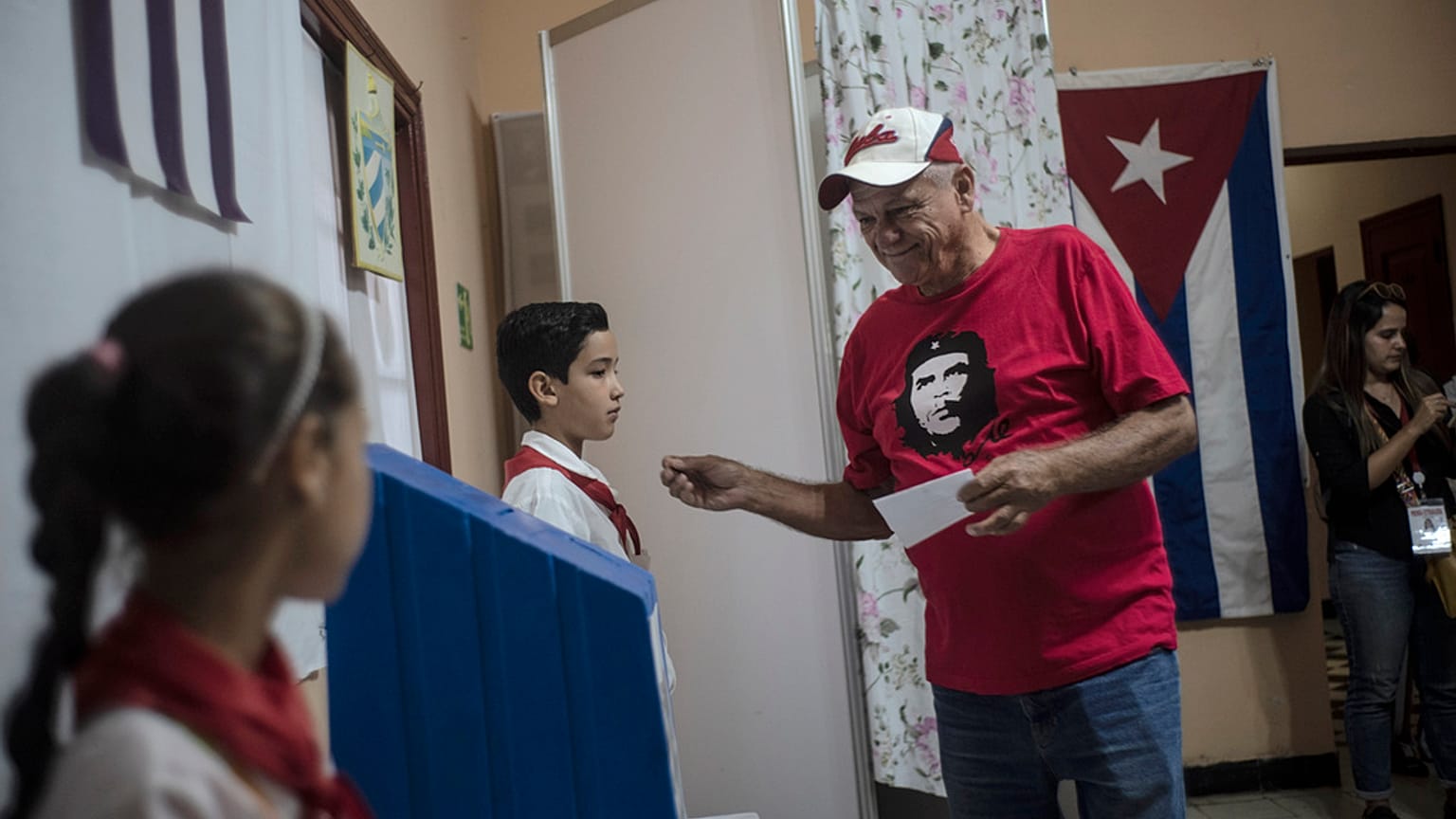 Egy Che Guevara arcképét viselő férfi készül szavazni Havannában