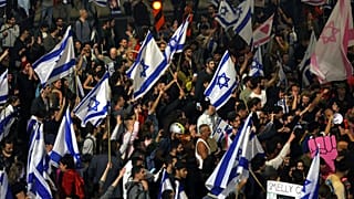 Israelis opposed to PM Benjamin Netanyahu's judicial overhaul plan block a highway during a protest after the leader fired his defence minister, in Tel Aviv, March 26, 2023
