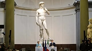 Former German Chancellor Angela Merkel and ex-Italian Prime Minister Matteo Renzi holding a press conference in front of Michelangelo's David in 2015. -