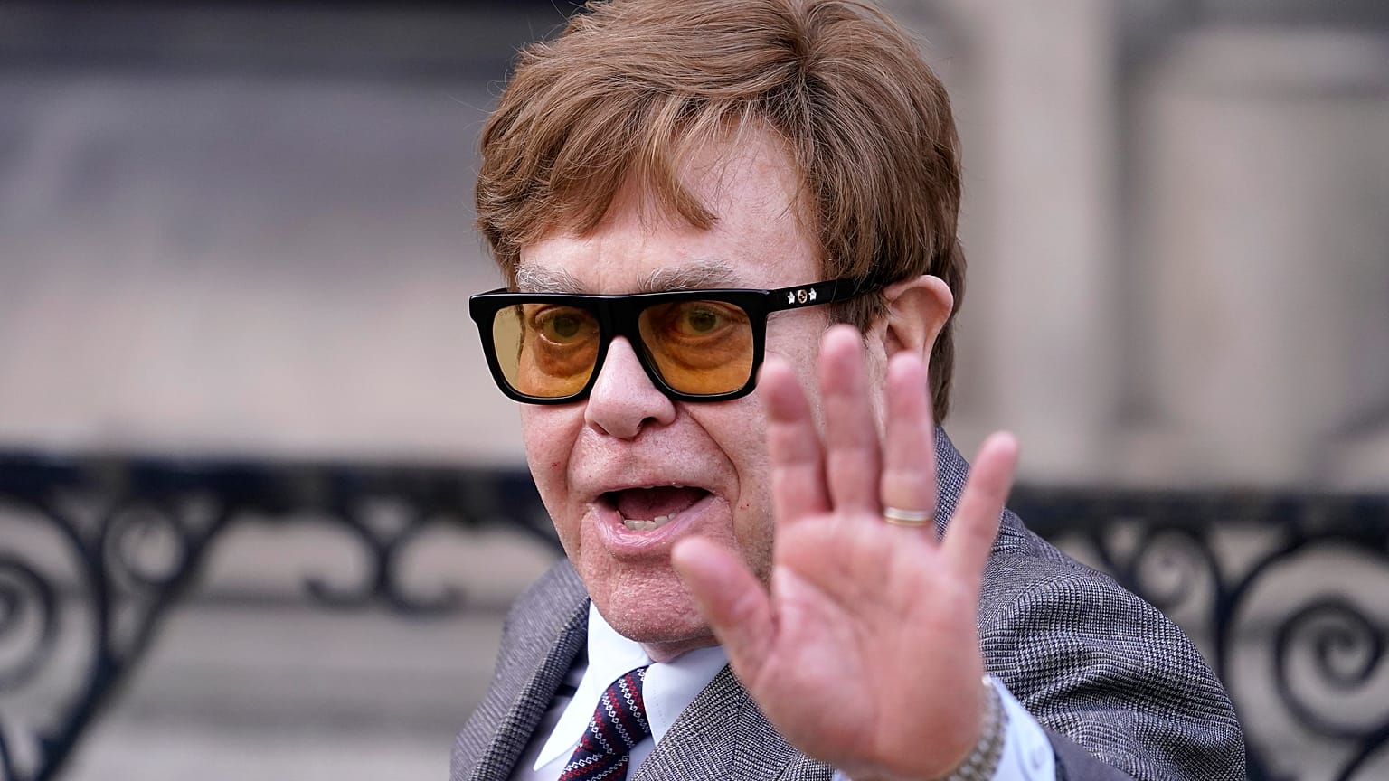 El músico Elton John saluda a los periodistas a su salida del Tribunal Superior de Londres el lunes 27 de marzo