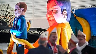 Scholz in den Fängen von Chinas Staatschef Xi Jinping - in der Pappmaché-Version - beim Rosenmontagsumzug in Köln, 14. Feburar 2023