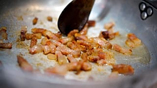 Pieces of guanciale (pork cheek) are sizzled in a pan during a cooking competition on the eve of the Carbonara Day, an event created by the the Italian Food Union, in Rome.
