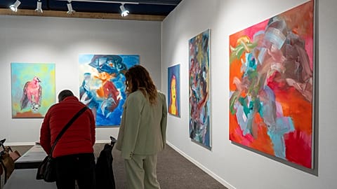 Visitors look at art exhibited at one of the stands at Art Paris.