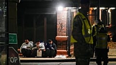 افرادی که تصور می‌شود مهاجر هستند توسط پلیس در خارج از مرکز نگهداری کوتاه مدت مهاجران در انگلستان بازداشت شده‌اند/ نوامبر ۲۰۲۲