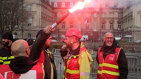 CGT union member raises a flare during a demonstration in Lille, northern France Thursday March 30, 2023
