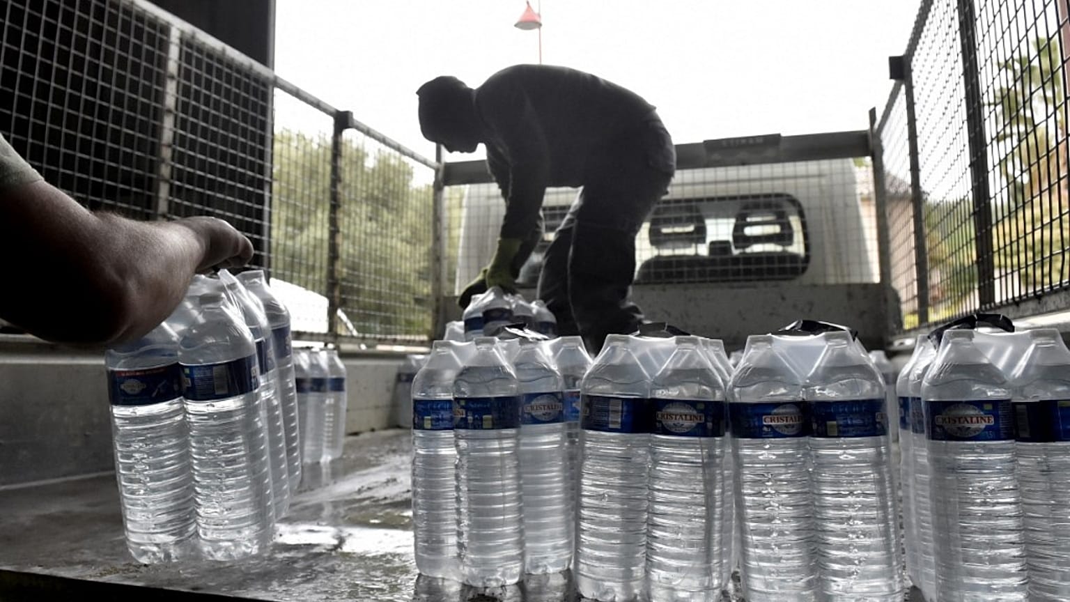 Municipal employees load packages of drinking water to be delivered to the residents of Corbere-les-Cabanes, southwestern France.