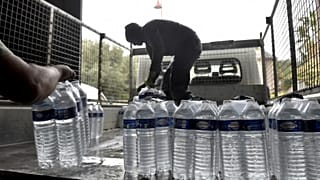 Municipal employees load packages of drinking water to be delivered to the residents of Corbere-les-Cabanes, southwestern France.