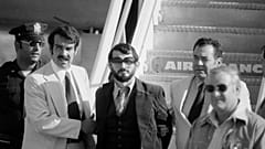 Zvonko Busic, com barba, é conduzido de um avião sob custódia policial no Aeroporto Kennedy, Nova Iorque, depois de ter sido preso por pirataria aérea. 12 de Setembro de 1976