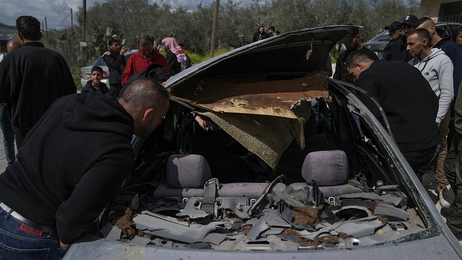 فلسطينيون يتفقدون مركبة مدمرة قُتل فيها ثلاثة مسلحين فلسطينيين برصاص القوات الإسرائيلية في قرية جبع بالضفة الغربية، بالقرب من جنين، 9 آذار 2023.