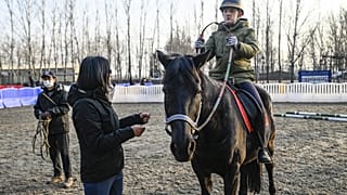 فيكتور ليو يعاني من ضعف البصر والتوحد، يحضر درساً في ركوب الخيل في نادٍ للخيول في بكين، 15 فبراير 2023