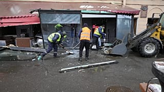 Trabalhadores municipais limpam o local da explosão.