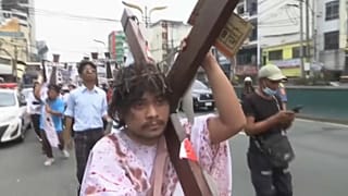 Manifestante carrega grande cruz pelas ruas da capital das Filipinas