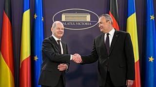 German Chancellor Olaf Scholz shakes hands with his Romanian counterpart Nicolae Ciuca at the Victoria Palace, the Romanian government headquarters.