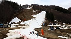 Skiers stand on an artificial snow slope as end of the ski season nears in Monte Cimone, Italy, 31 March 2023. 
