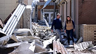 Wynne School Superintendent Kenneth Moore, left, leads Gov. Sarah Huckabee Sanders through the Wynne High School that was hit by Friday's tornado