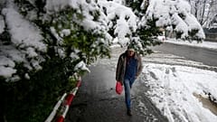 Un homme marche dans une rues enneigée de Belgrade, en Serbie. 4 avril 2023