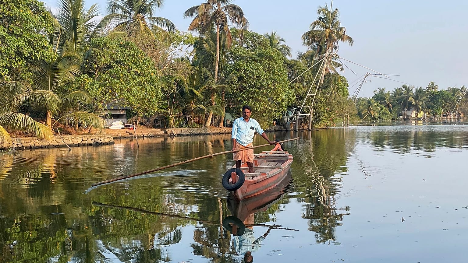 A man travels by boat from one district to another to help people get clean water in Kochi, Kerala state, India, on March 1, 2023. 