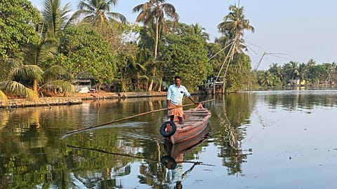 A man travels by boat from one district to another to help people get clean water in Kochi, Kerala state, India, on March 1, 2023. 