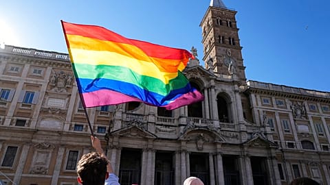 A demonstrator waves the rainbow flag in front of the Basilica of Saint Mary Major during the annual Pride march, in Rome, Saturday, June 26, 2021. 