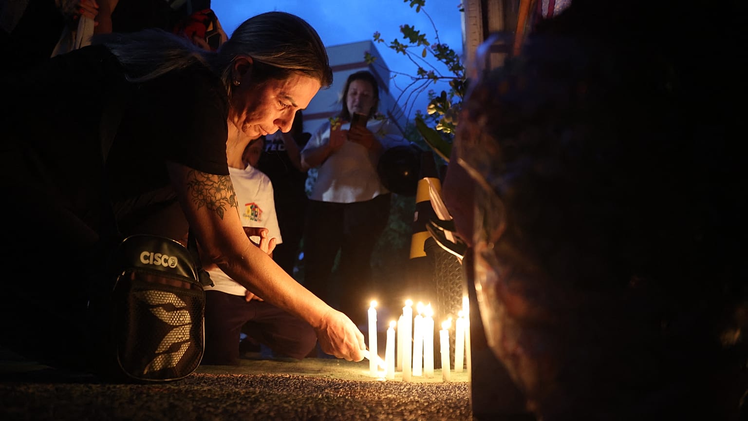 Des habitants posent des bougies en hommage aux quatre enfants tués.