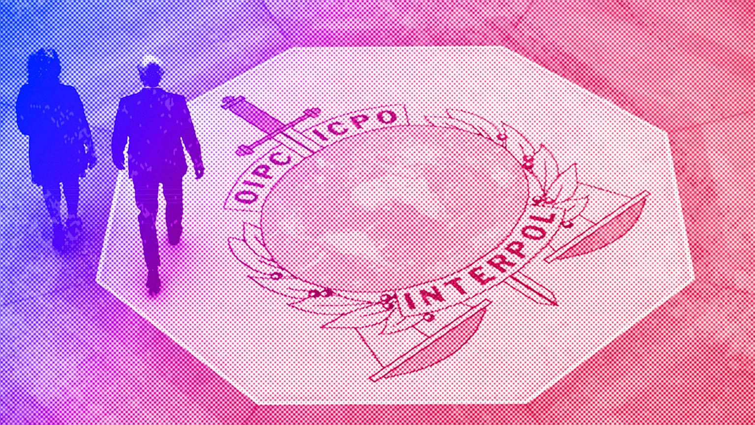 People walk on the Interpol logo at the international police agency headquarters in Lyon, November 2018