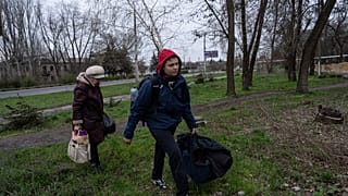 Ein Jugendlicher und eine Frau verlassen Bachmut
