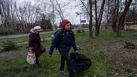 Ein Jugendlicher und eine Frau verlassen Bachmut