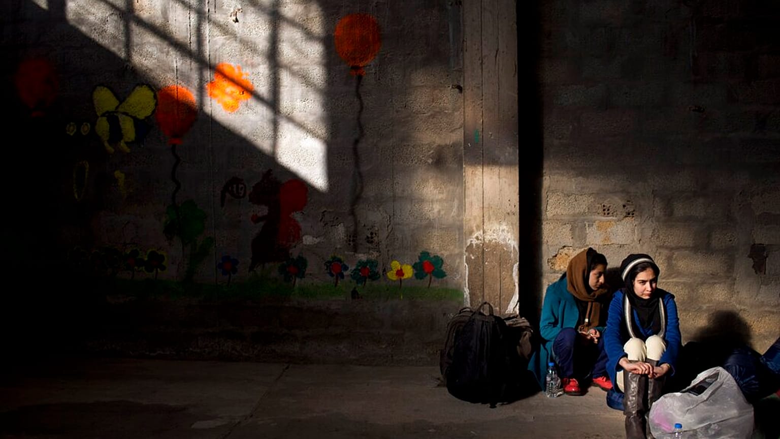 Two women wait to receive aid in Greece.